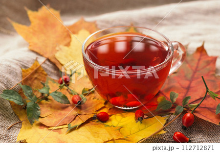 A cup of rose hip tea with fresh berries in a glass cup. Vintage background, selective focus 112712871