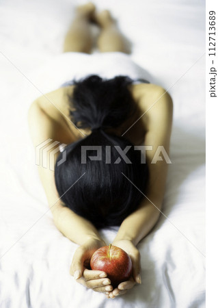 A woman lying in a white towel on the bed 112713689