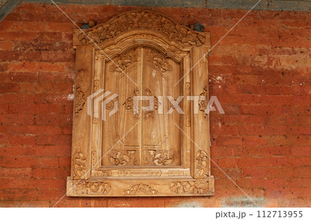 Homemade wooden sashes on a window in a traditional Balinese house. 112713955