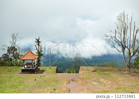 The gazebo stands on a cloud-shrouded mountain on the popular tourist island of Bali. The gazebo stands on a cloud-shrouded mountain on the popular tourist island of Bali. 112713981