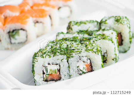 Philadelphia roll in plastic container on white background. Uramaki rolls. Philadelphia roll in plastic container on white background. Uramaki rolls. 112715249