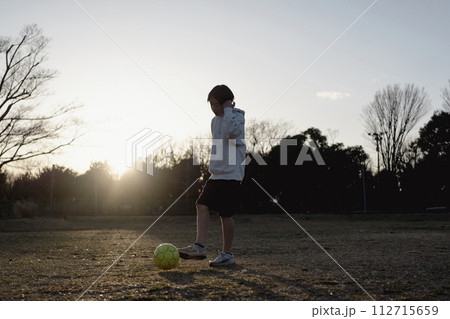 夕暮れまでサッカーを楽しむ子ども 112715659