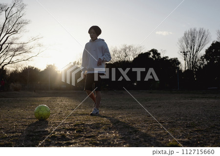 夕暮れまでサッカーを楽しむ子ども 112715660