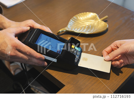 お店でクレジットカード払いをする手元 お店でクレジットカード払いをする手元 112716193