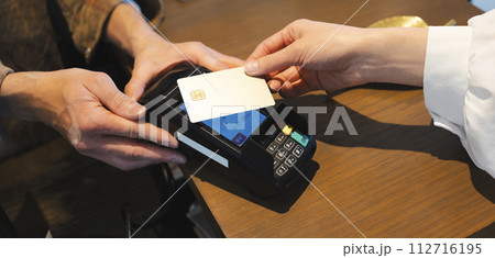 お店でクレジットカード払いをする手元 112716195