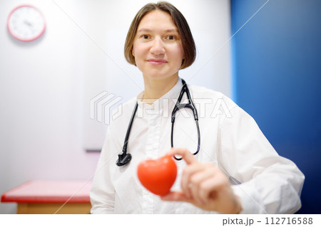 Female cardiologist holding red heart. Cardiology concept. 112716588