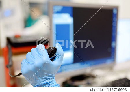 Radiologist is going to take X ray of patient in X-ray room of modern clinic. Close up photo of doctor hand presses button for execute of medical examination 112716608