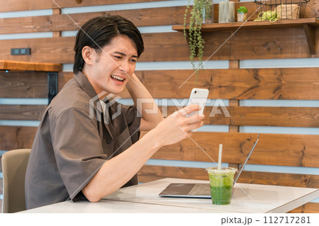 カフェでスマホとパソコンを使う若いアジア人男性(驚く・投資・失敗・トラブル・ショック) カフェでスマホとパソコンを使う若いアジア人男性(驚く・投資・失敗・トラブル・ショック) 112717281