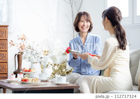 母の日 カーネーションとプレゼントをもらうお母さん 母の日 カーネーションとプレゼントをもらうお母さん 112717324