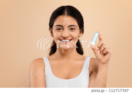 Portrait Of Beautiful Young Indian Woman Holding Hygienic Lipstick And Smiling 112717397