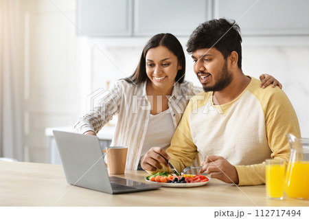 Happy eastern spouses planning vacation while have breakfast 112717494