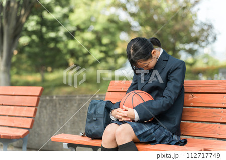 バスケットボールを持って悩む女子中学生・女子高生（部活・スポーツ・運動部・バスケ部） 112717749