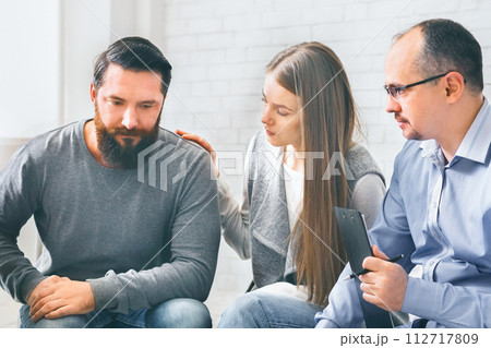 Group supporting depressed man with alcoholism problem Group supporting depressed man with alcoholism problem 112717809