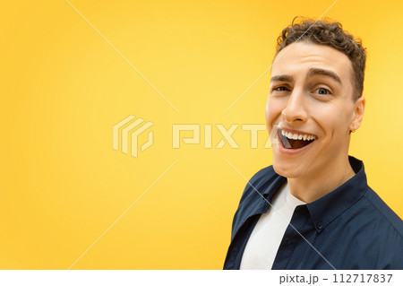 Closeup of funny young guy posing over yellow background 112717837