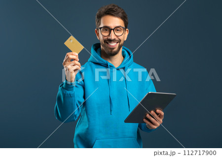 Online Payments. Cheerful Young Man Using Digital Tablet And Credit Card 112717900
