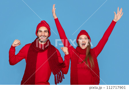 Holiday Spirit. Portrait Of Overjoyed Young Couple Wearing Winter Hats Celebrating Success Holiday Spirit. Portrait Of Overjoyed Young Couple Wearing Winter Hats Celebrating Success 112717901