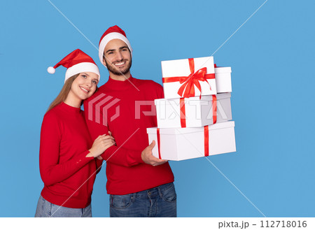 Christmas Presents. Happy Young Couple With Gift Boxes In Hands Christmas Presents. Happy Young Couple With Gift Boxes In Hands 112718016