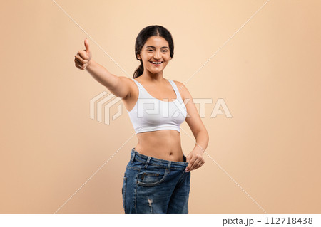 Weight Loss Result. Indian Woman Wearing Oversized Jeans And Showing Thumb Up 112718438