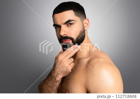Cool photo of Middle Eastern guy posing shirtless on grey 112718608