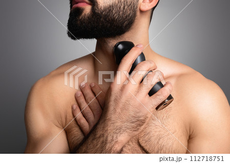 Cropped of young muscular man trimming his beard Cropped of young muscular man trimming his beard 112718751