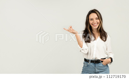 Radiant young woman with long brunette hair and glasses, wearing a white blouse and blue jeans Radiant young woman with long brunette hair and glasses, wearing a white blouse and blue jeans 112719170