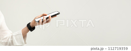 Close-up of a hand holding a smartphone with a white screen, featuring a woman in a white blouse 112719359