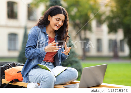 Eastern young lady student have online exam, using laptop outdoors 112719548