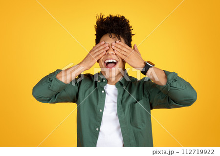 Excited african american guy closed his eyes with palms Excited african american guy closed his eyes with palms 112719922