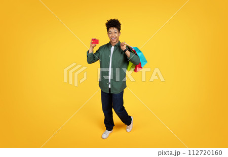 Cool black guy enjoying unlimited shopping, full length 112720160