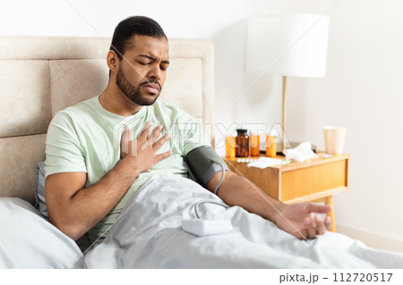 Unhealthy african american man doing morning checkup after waking up Unhealthy african american man doing morning checkup after waking up 112720517