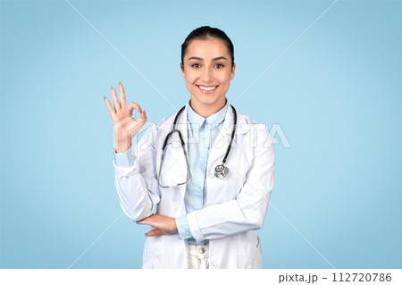 Young doctor woman giving okay sign in lab coat Young doctor woman giving okay sign in lab coat 112720786