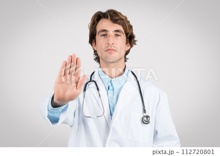 Serious male doctor gesturing stop with hand, healthcare concept Serious male doctor gesturing stop with hand, healthcare concept 112720801