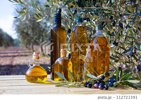 Glass bottles and carafes with olive oil 112721391