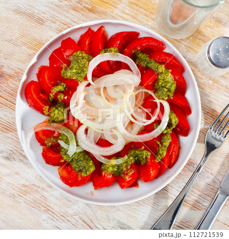 Colorful tomato salad with onions and basil pesto Colorful tomato salad with onions and basil pesto 112721539