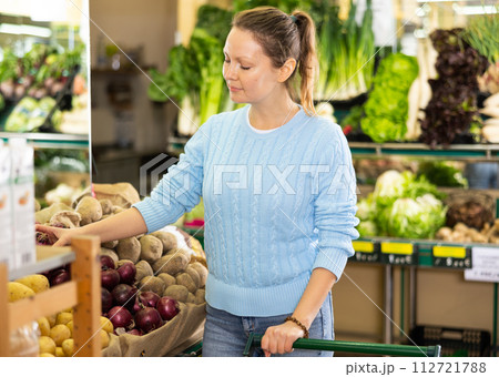 woman buy large onion in supermarket 112721788