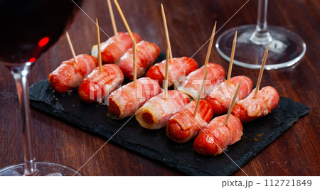 Spanish tasty meal rolled in bacon sausages at plate 112721849