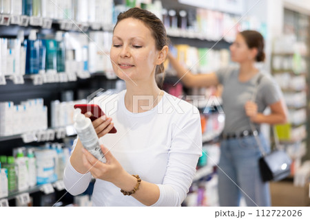 In pharmacy visitor scan QR Code and reads composition of cream for problematic skin. In pharmacy visitor scan QR Code and reads composition of cream for problematic skin. 112722026