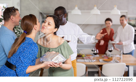 Happy middle-aged pair welcoming their guests at home Happy middle-aged pair welcoming their guests at home 112722090