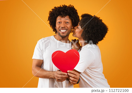 Romantic african american couple celebrating anniversary on orange 112722100
