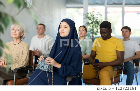 Positive multinational students listening to lecture in classroom Positive multinational students listening to lecture in classroom 112722161