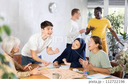 Group of of different years people playing tabletop game 112722196