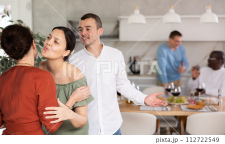 Happy middle-aged pair welcoming a woman at home 112722549