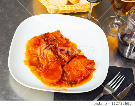 Stewed pork loin in a sauce , served with roasted potatoes Stewed pork loin in a sauce , served with roasted potatoes 112722690