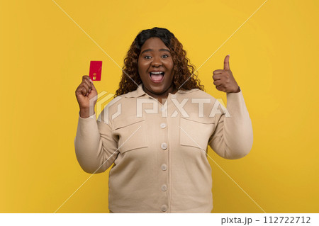 Happy chubby african american woman showing credit card Happy chubby african american woman showing credit card 112722712