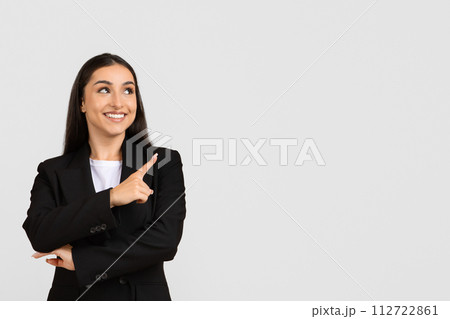 Smiling businesswoman pointing up and side at free space 112722861