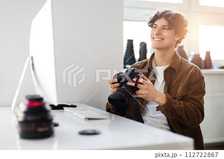 Happy male photographer reviewing images on DSLR camera Happy male photographer reviewing images on DSLR camera 112722867