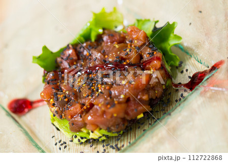 Image of salmon tartar with avocado and salad on glass plate Image of salmon tartar with avocado and salad on glass plate 112722868