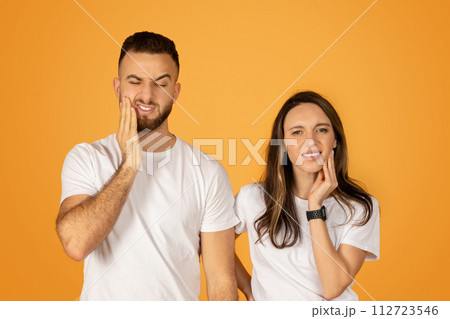 Young man and woman in white shirts showing toothache discomfort 112723546