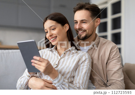 Happy european spouses sharing moment with digital tablet 112723593