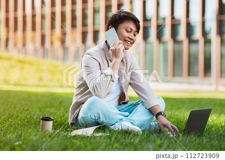 Taiwanese young man entrepreneur working on laptop outdoors 112723909